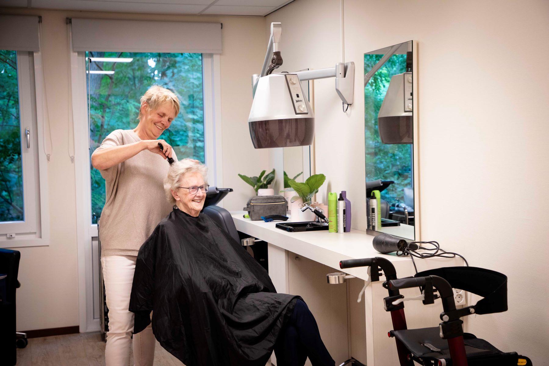 Vrouw zit in kappersstoel