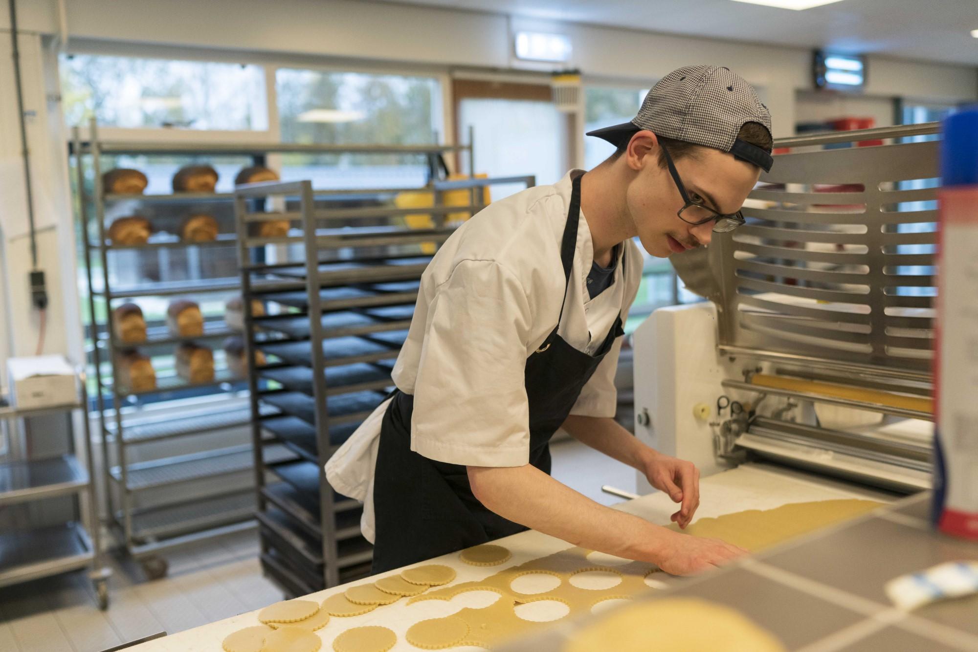 medewerker maakt koekjes in bakkerij boschwijk