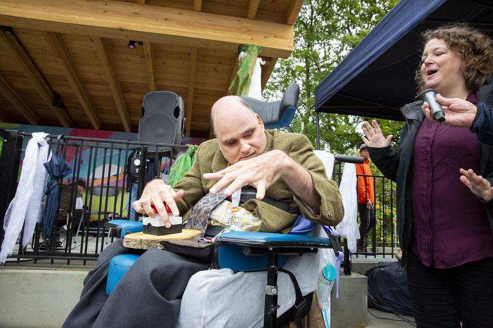 Bewoner Arjan drukt op de rode knop voor de opening van de Muziekkoepel.