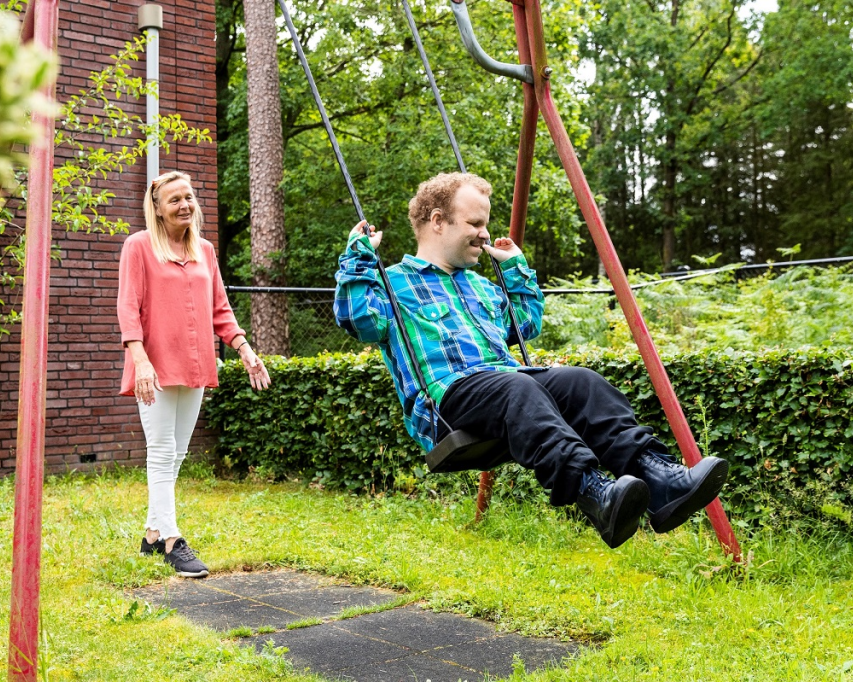 client schommelt en begeleidster duwt