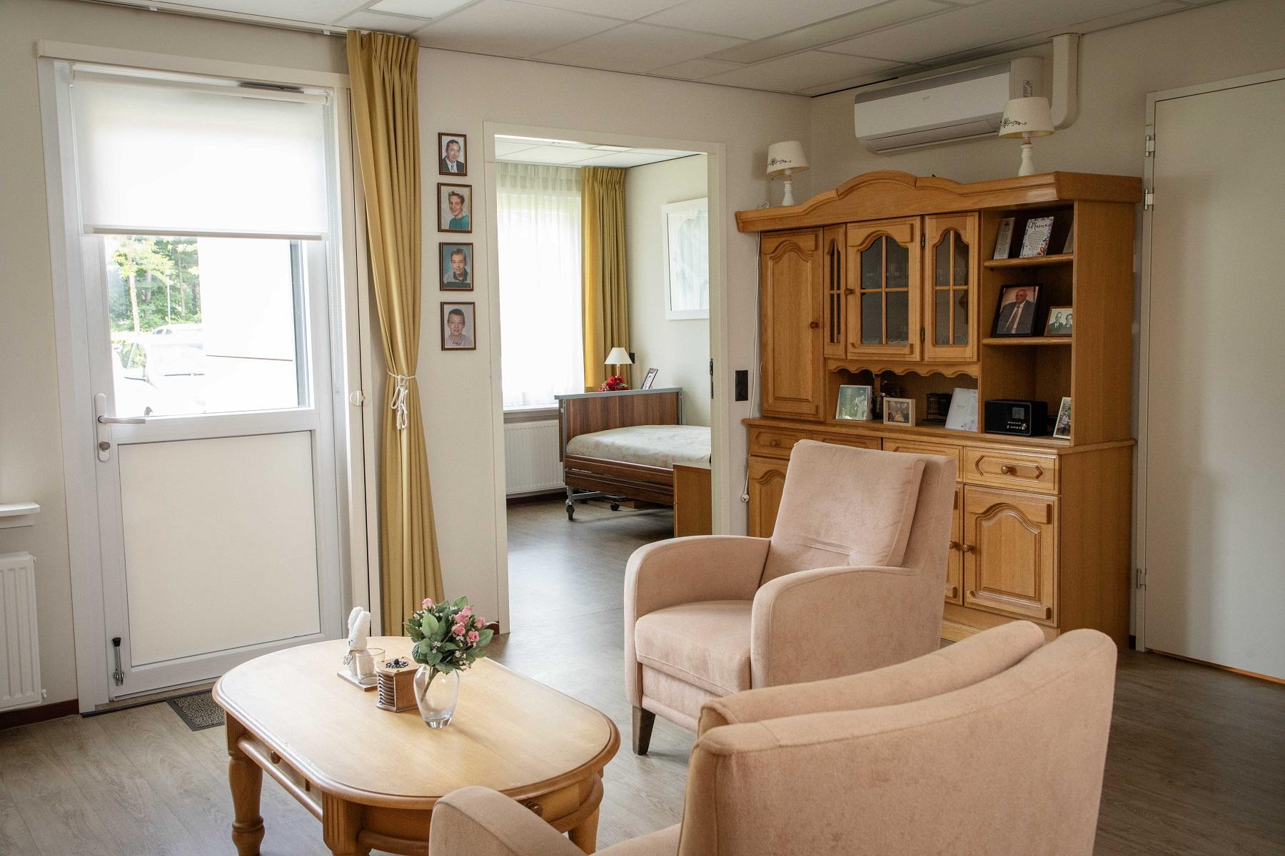 woonkamer met salontafel, stoelen en kast