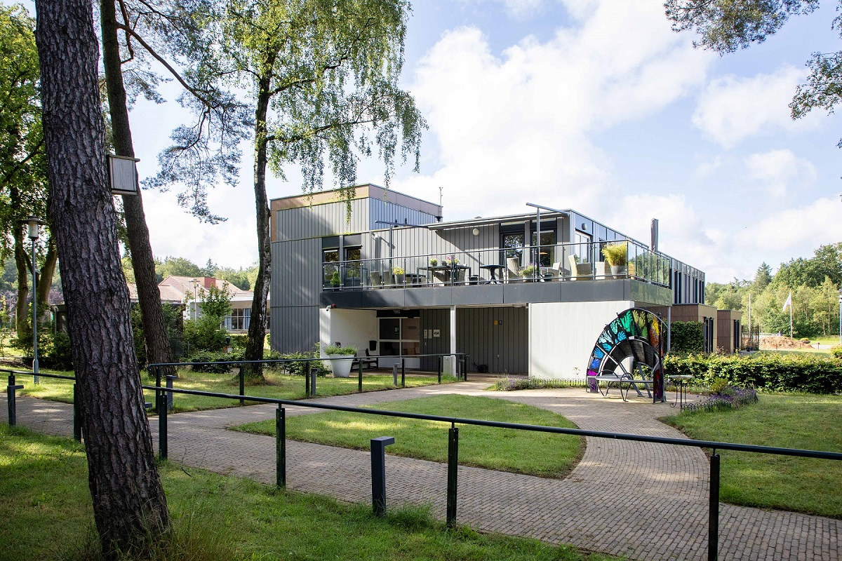 woongebouw omringd door gras en bomen