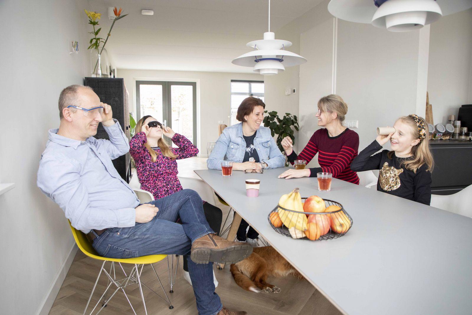 Gezin aan tafel met begeleider