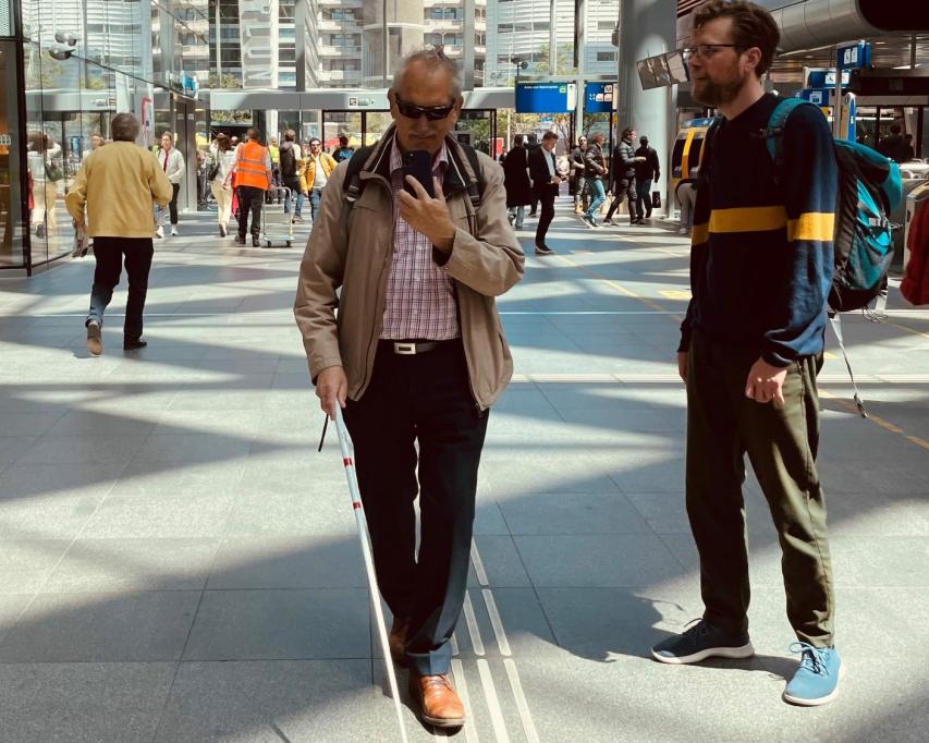 Man test indoornavigatie app op station