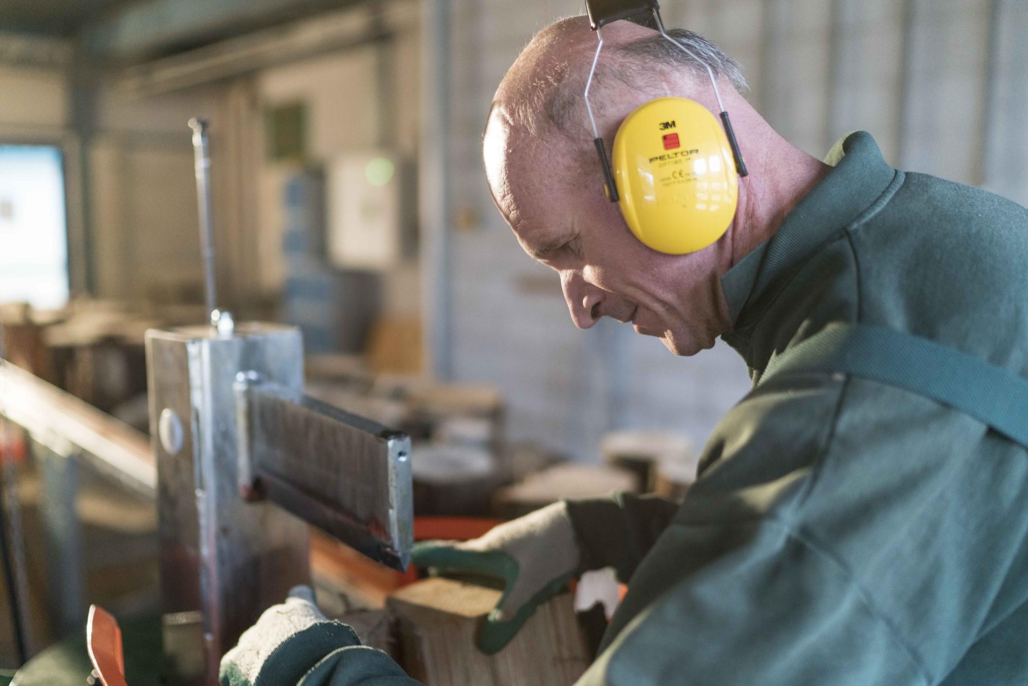 man aan het werk in houtkloverij