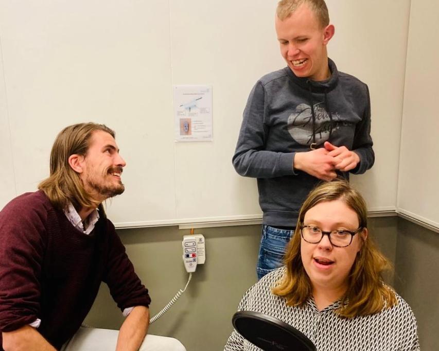 Melissa en Christiaan spreken de teksten, begeleider Rik is hier bij.