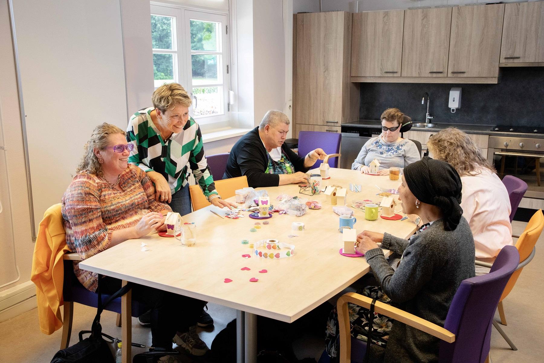 Groep vrouwen aan tafel met knutselmateriaal