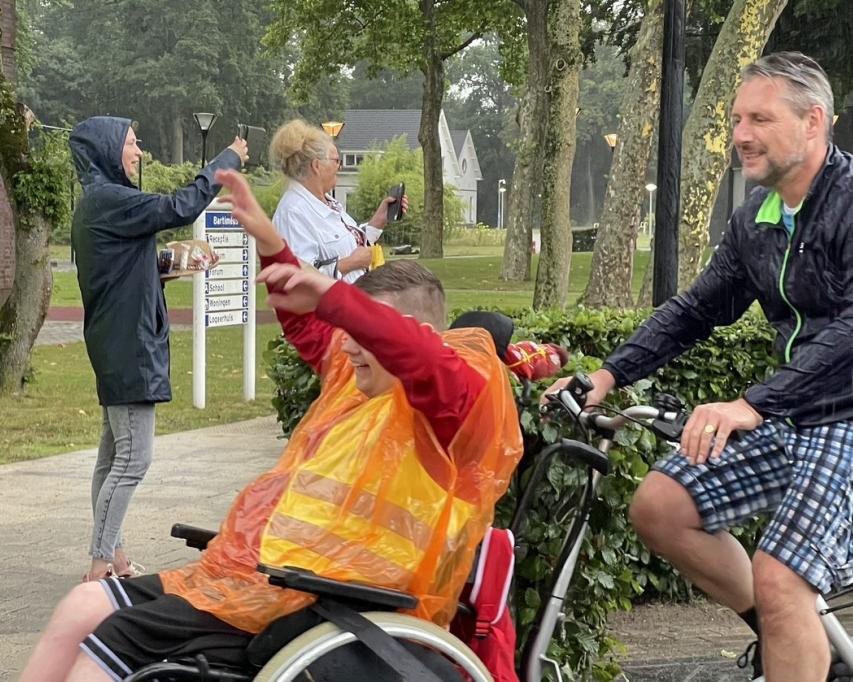 vrijwilliger met client op rolstoelfiets