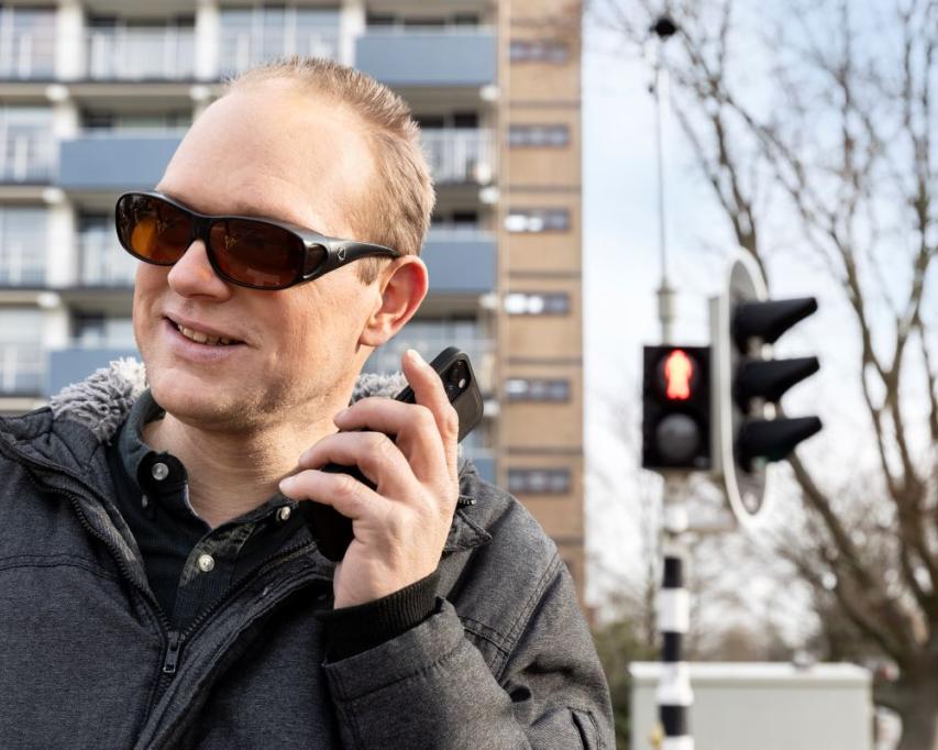 Man met smartphone in de hand steekt over