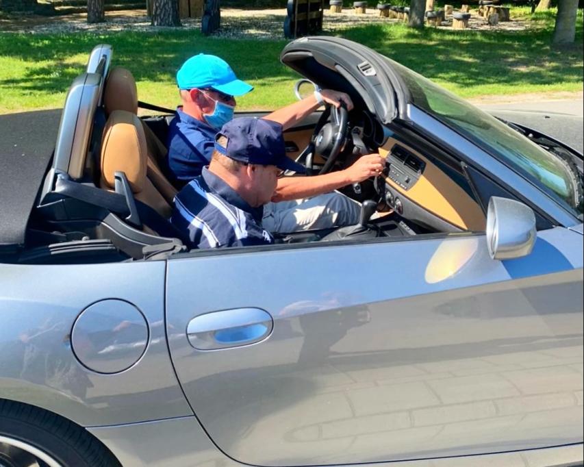 Vrijwilliger Huub rijdt met bewoner Dick in zijn cabrio.