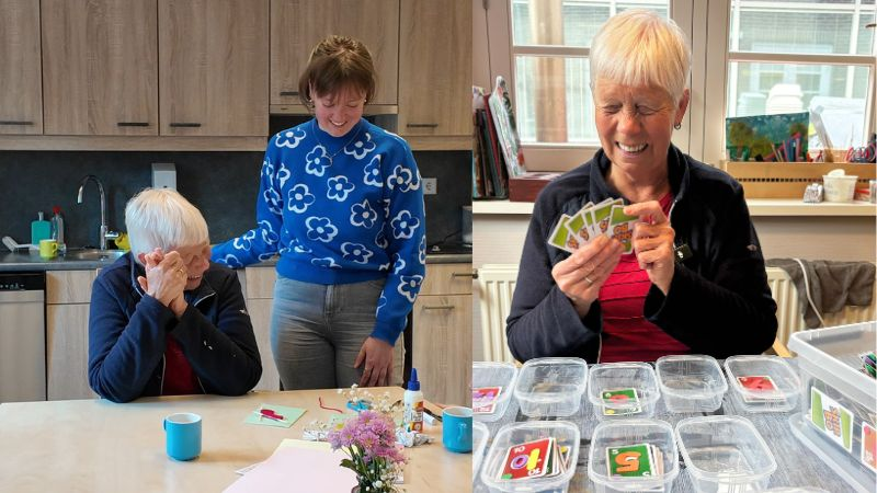 Neli zit aan tafel en speelt een spelletje Skipbo.