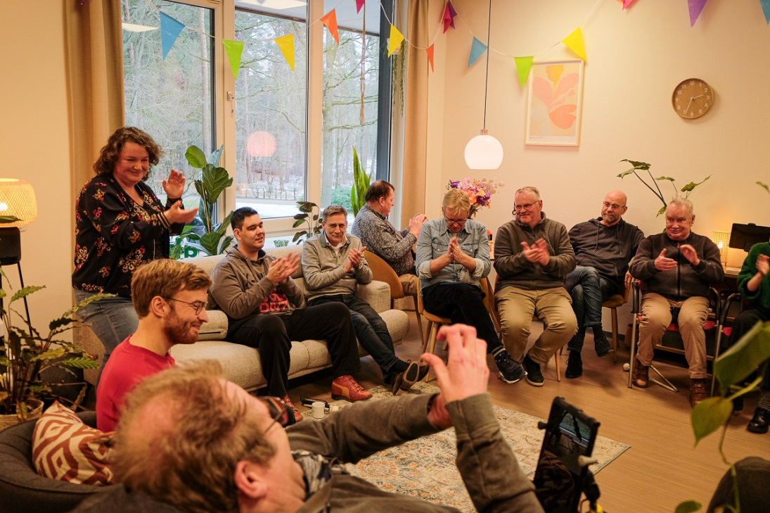Groep vrolijk klappende mensen zittend in een kring