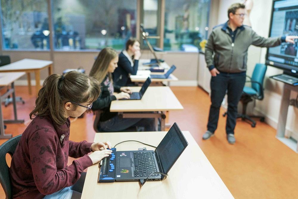 Leerkracht met 3 leerlingen in de klas