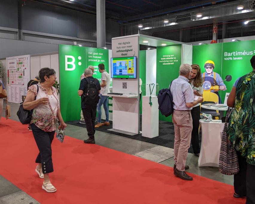 Bezoekers in groen witte Bartiméus-stand