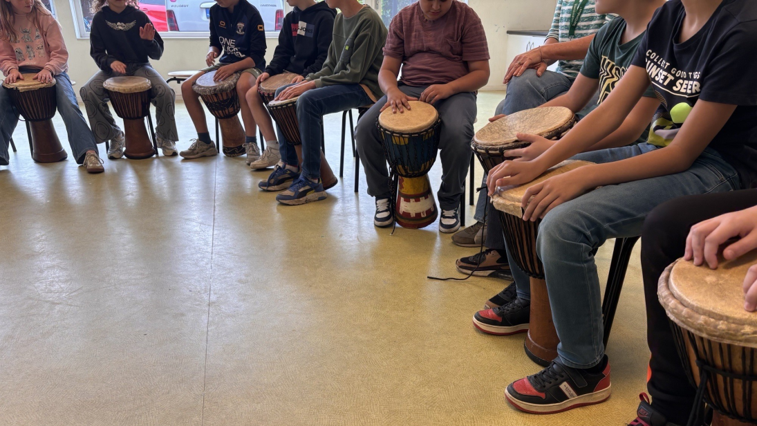 Leerlingen achter een djembé in de klas