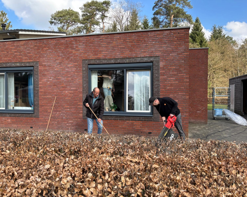 Twee mannen aan het werk in een tuin bij een Bartiméuswoning