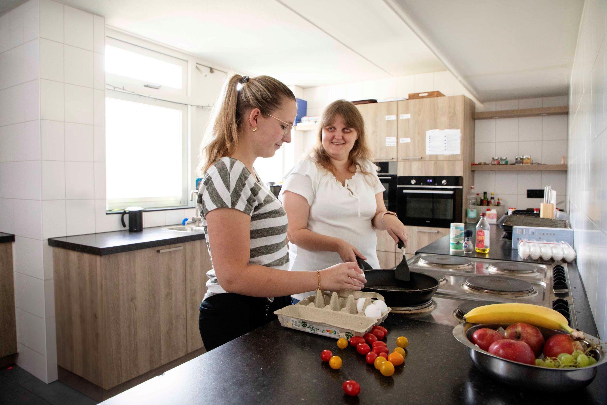 jongere kookt samen met begeleider