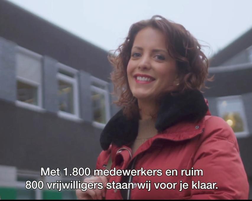 Een vrouw voor het hoofdgebouw van Bartiméus: Met 1800 medewerkers en ruim 800 vrijwilligers staan wij voor je klaar.