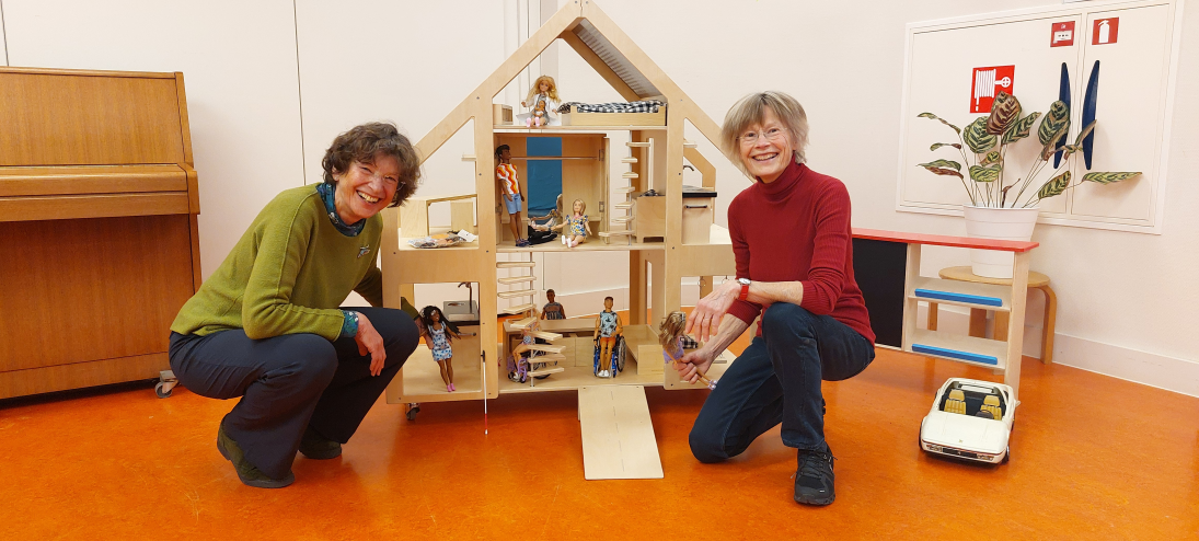 Medewerkers Ans en Ellen zittend naast de PoppenVilla