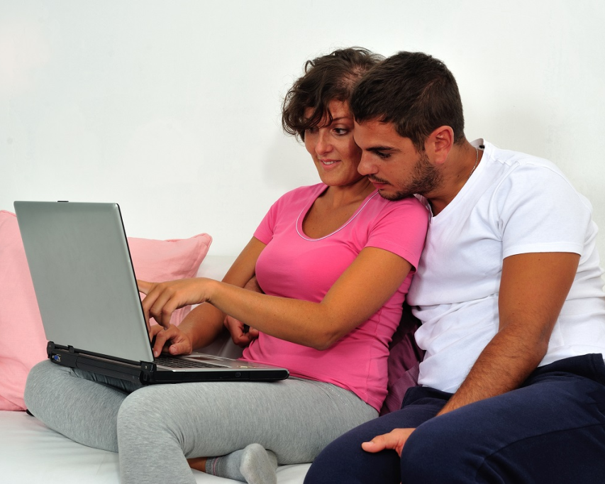 Man en vrouw kijken samen op scherm van laptop