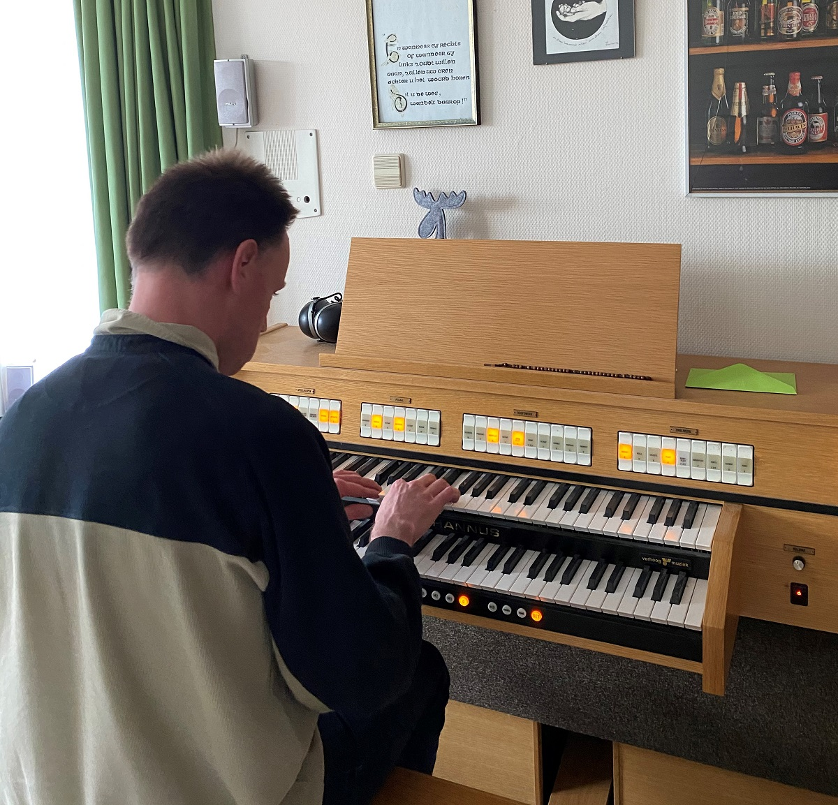 Bewoner Albert achter zijn orgel in zijn appartement.