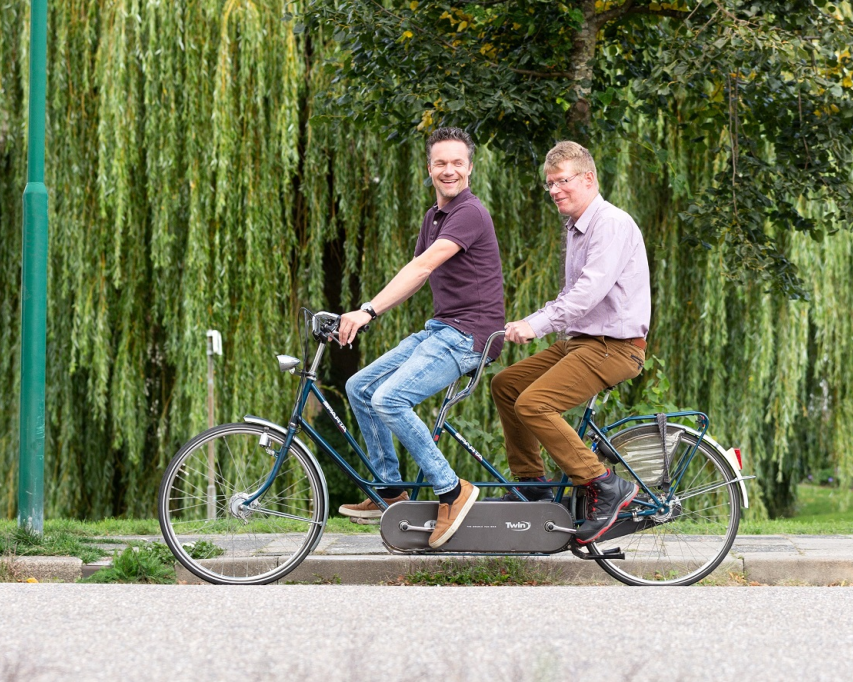 Vrijwilliger fietst op duofiets met cliënt