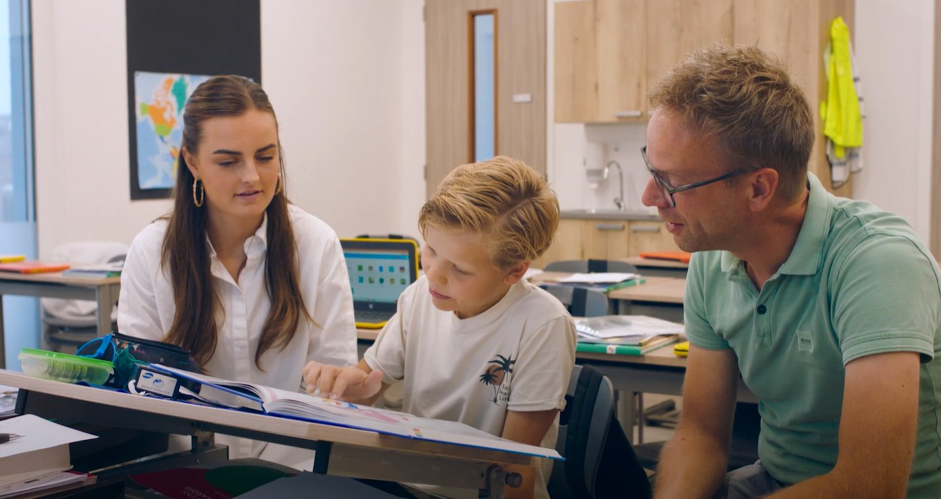 AOB-leerling Glenn in de klas met naast hem leerkracht en AOB'er Nico