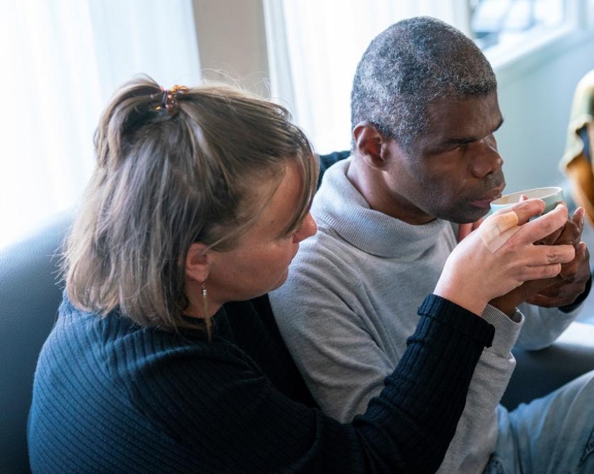 Begeleider helpt cliënt met drinken