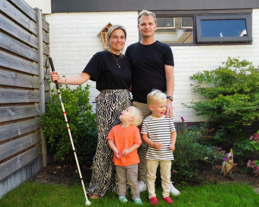 Lotte met een taststok in haar hand met partner en twee kinderen naast en voor haar