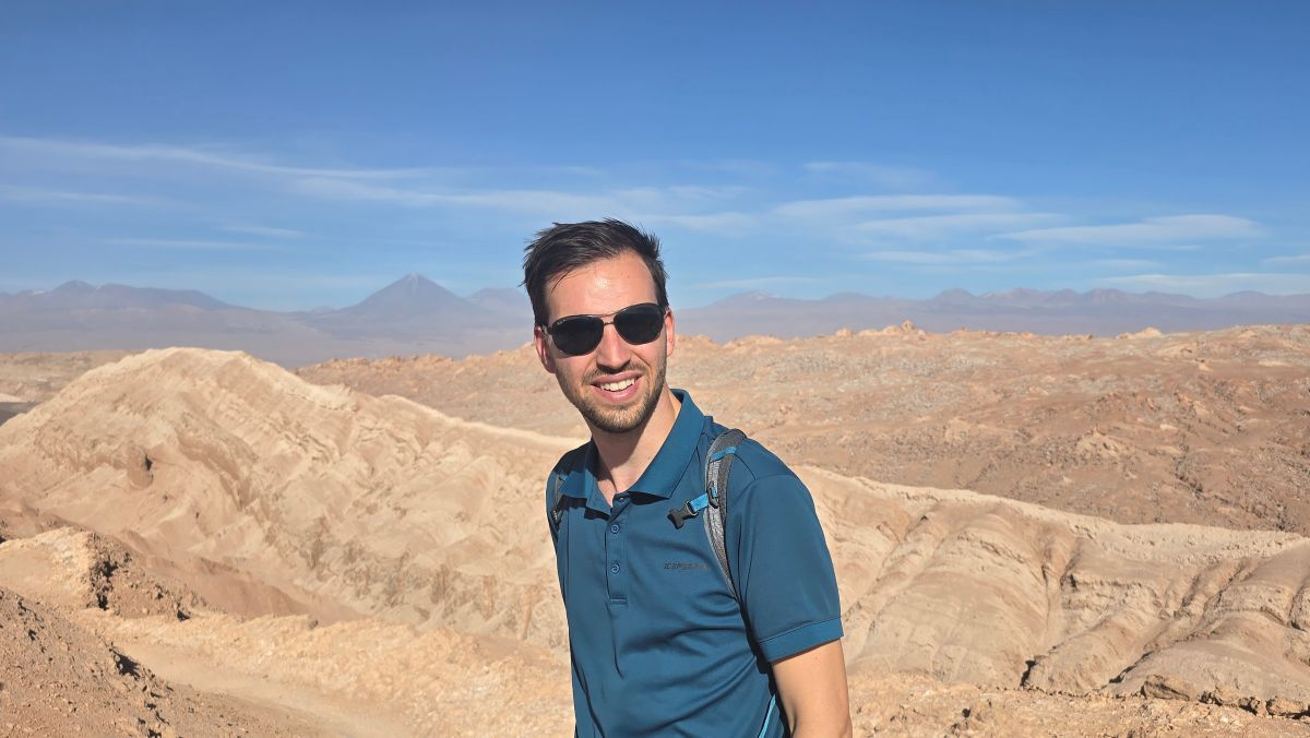 Arnout poseert voor een droog rotsachtige gebergte.