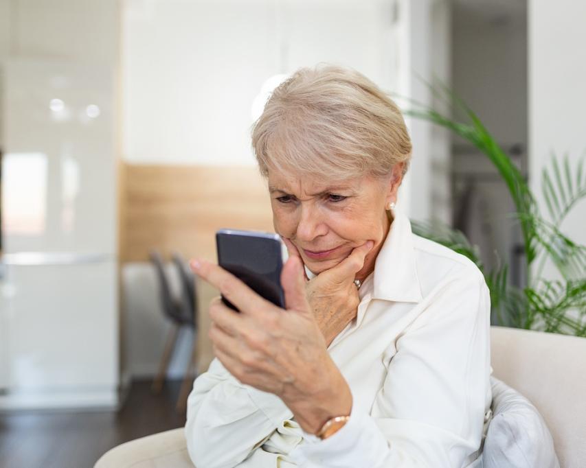 Vrouw kijkt aandachtig op haar mobiele telefoon