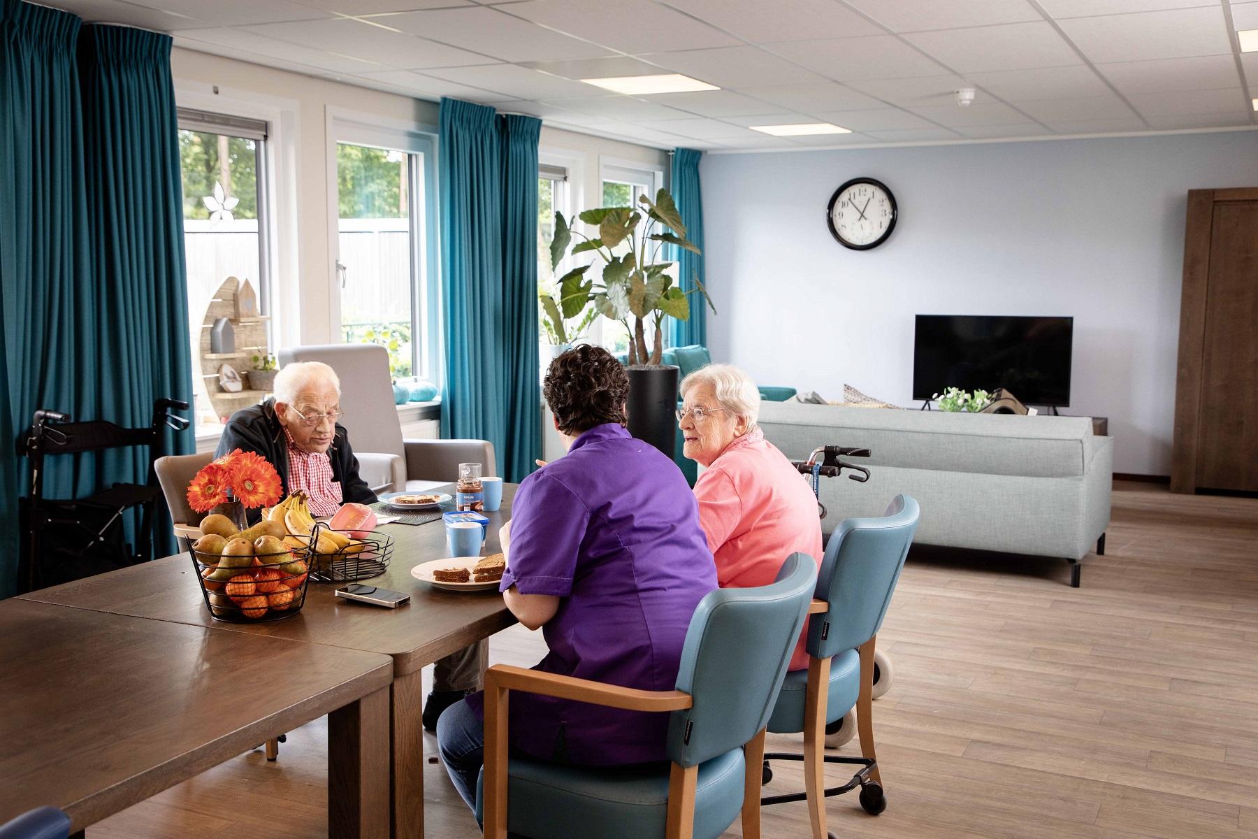 Ouderen zitten samen aan een tafel